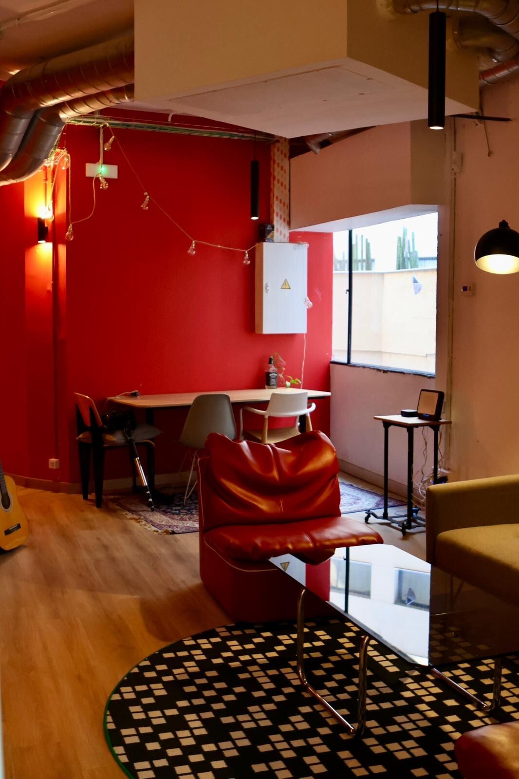Zona de estar con guitarra y mesa de reuniones